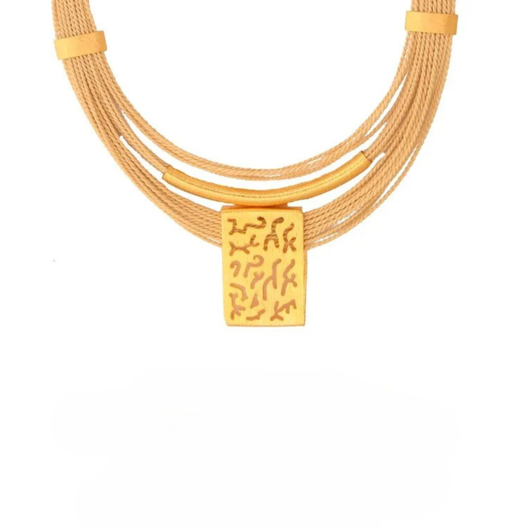 Collar artesanal en palha de burití con placa dorada texturizada – joyas sostenibles y elegantes hechas a mano