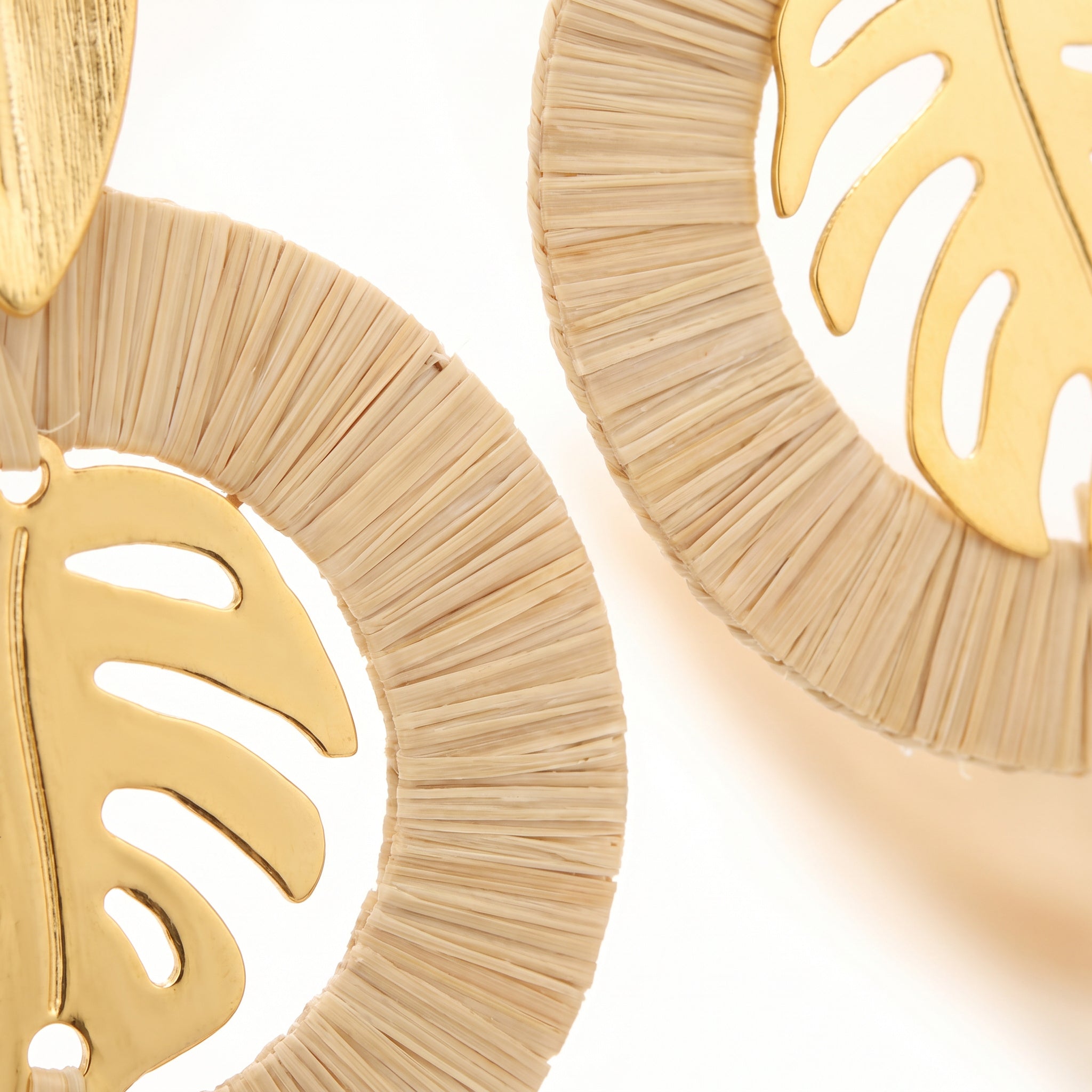 Close-up Purplee Store Buriti Artisanal Sorelia Set earrings with leaf designs on a light background
