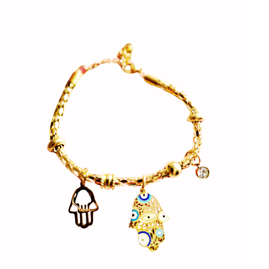 Pulsera dorada con dijes de mano de Fátima y ojo turco en colores azul, blanco y dorado. Diseño simbólico y protector con detalle brillante colgante.
