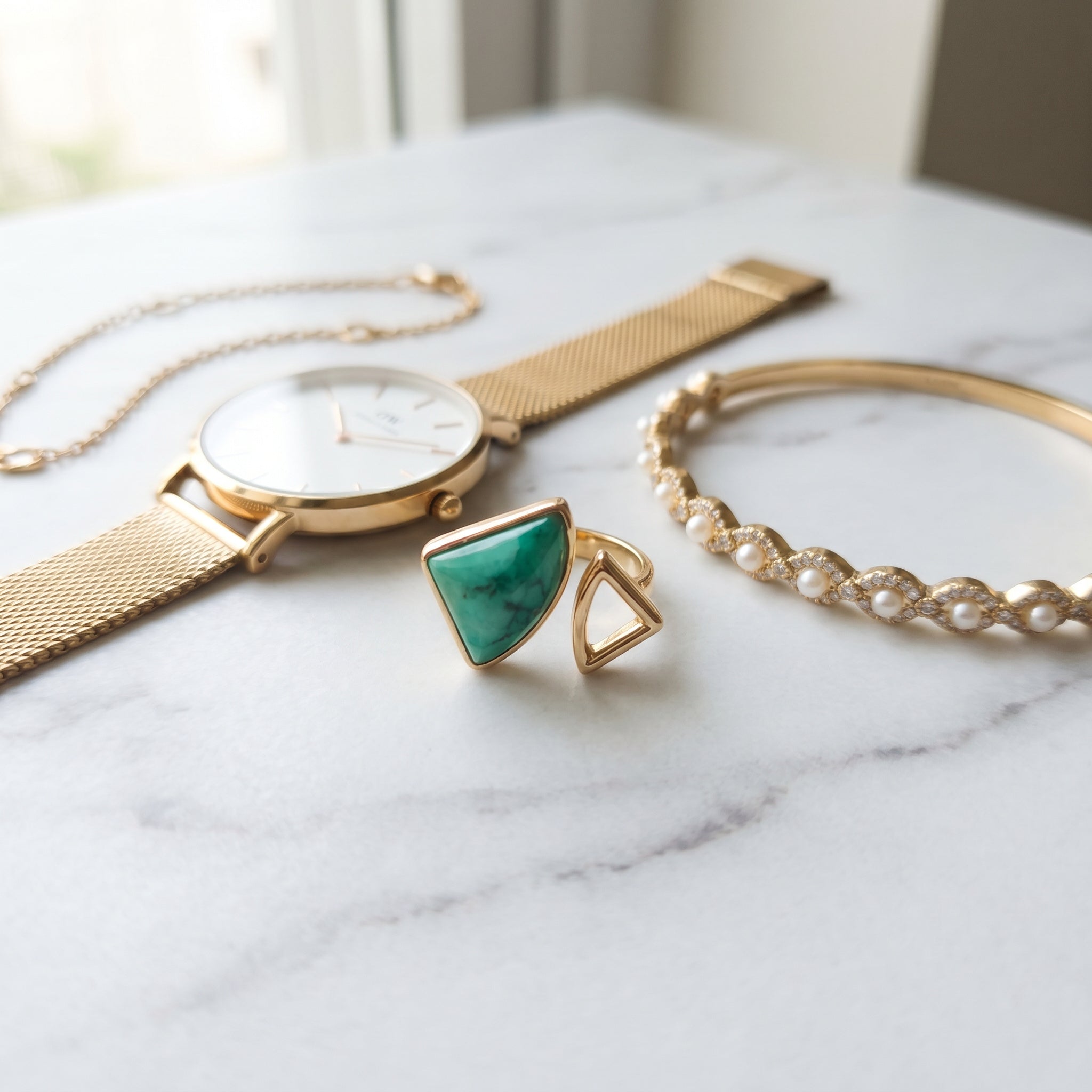 Purplee Store ELAN Geometric Bypass Ring Gold watch, and bracelet on a marble surface