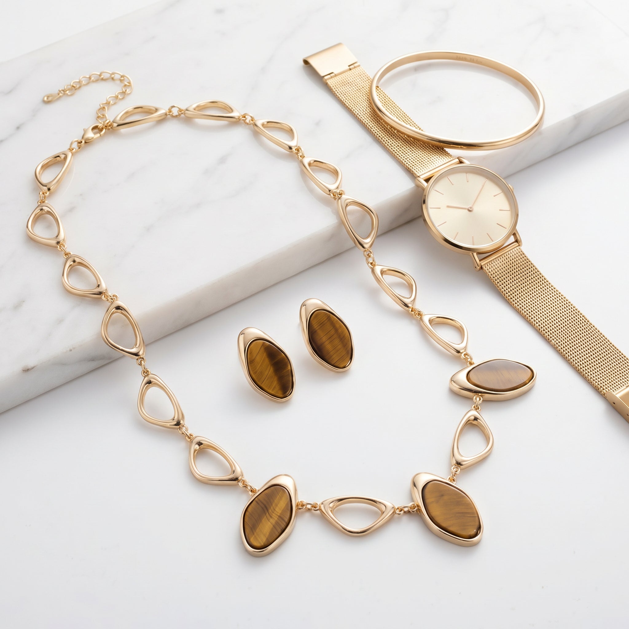 Purplee Store Earthly Opulence Ethereal Tiger’s Eye Statement Set and a gold watch on a marble surface