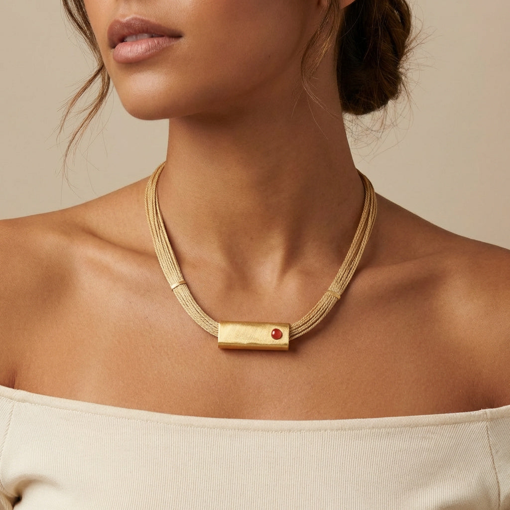 Model using a Fire Agatha Handcrafted Buriti Orvellia Necklace with Natural Stones and 18k Gold against a beige background. Purplee Store