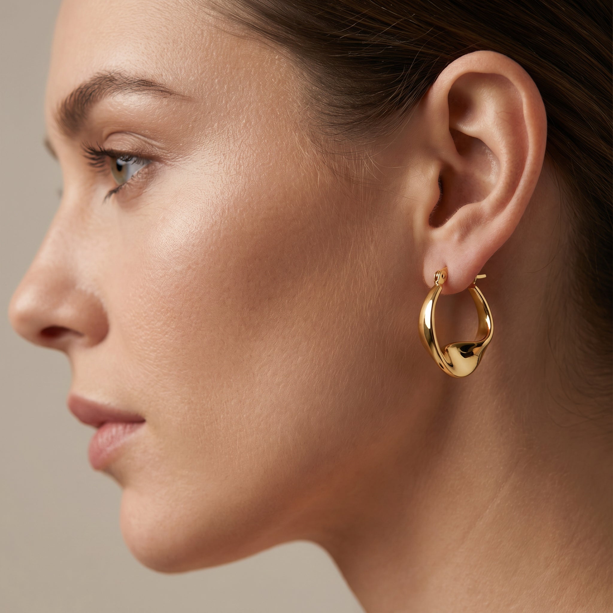 Woman using a Sculpt Twisted Gold Vermeil Hoops| Purplee Store