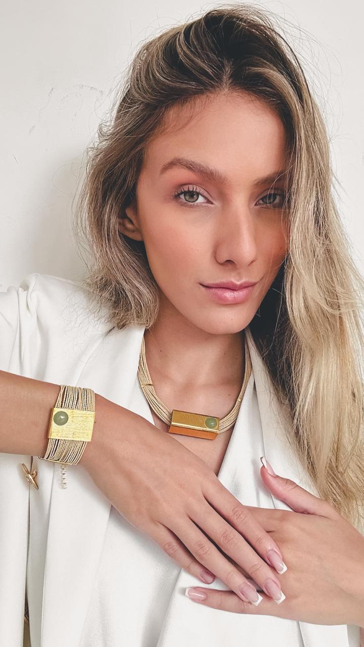 Mujer usando conjunto Collar y pulsera Quartzo Verde de Purplêe Store hechos a mano en palha de burití con piedra natural intercambiable (ágata, cuarzo verde o madreperla) – joyas sostenibles de diseño minimalista