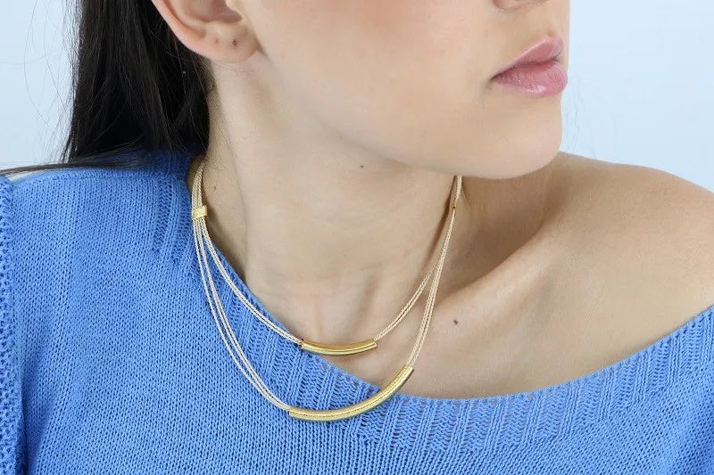 Mujer usando Collar artesanal doble con hilos de burití y detalles dorados – joya sostenible y elegante hecha a mano