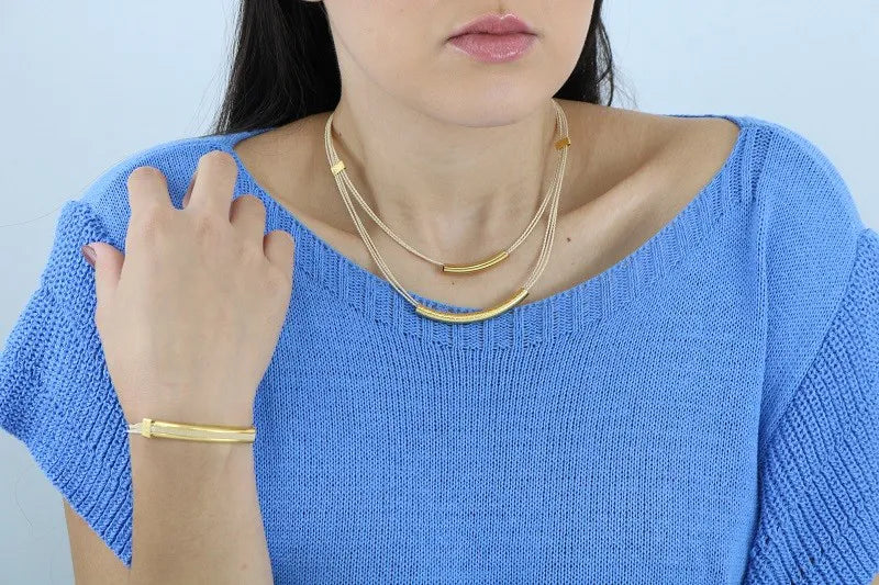 Mujer usando pulsera y Collar artesanal doble con hilos de burití y detalles dorados – joya sostenible y elegante hecha a mano