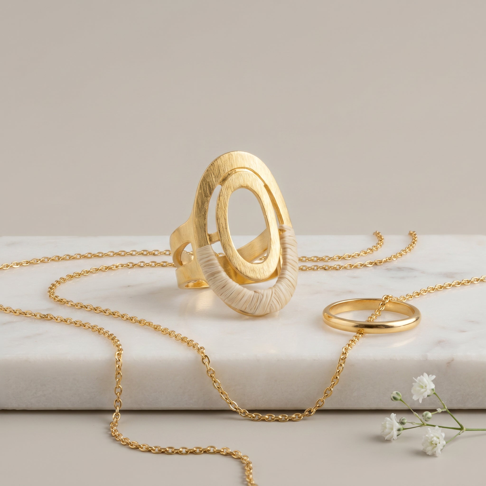 Gold jewelry including a necklace and Purplee Store Buriti Orliane Ring | Exotic Vegan Silk on a light background