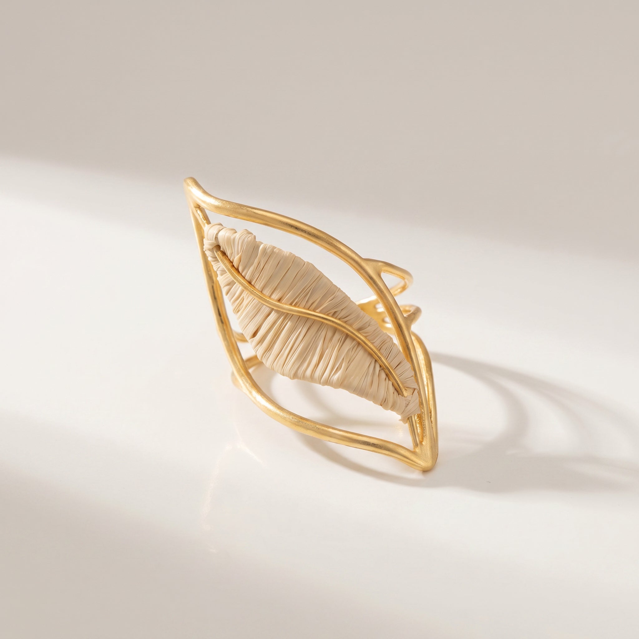 Purplee Store Gold leaf-shaped hair clip on a light beige background