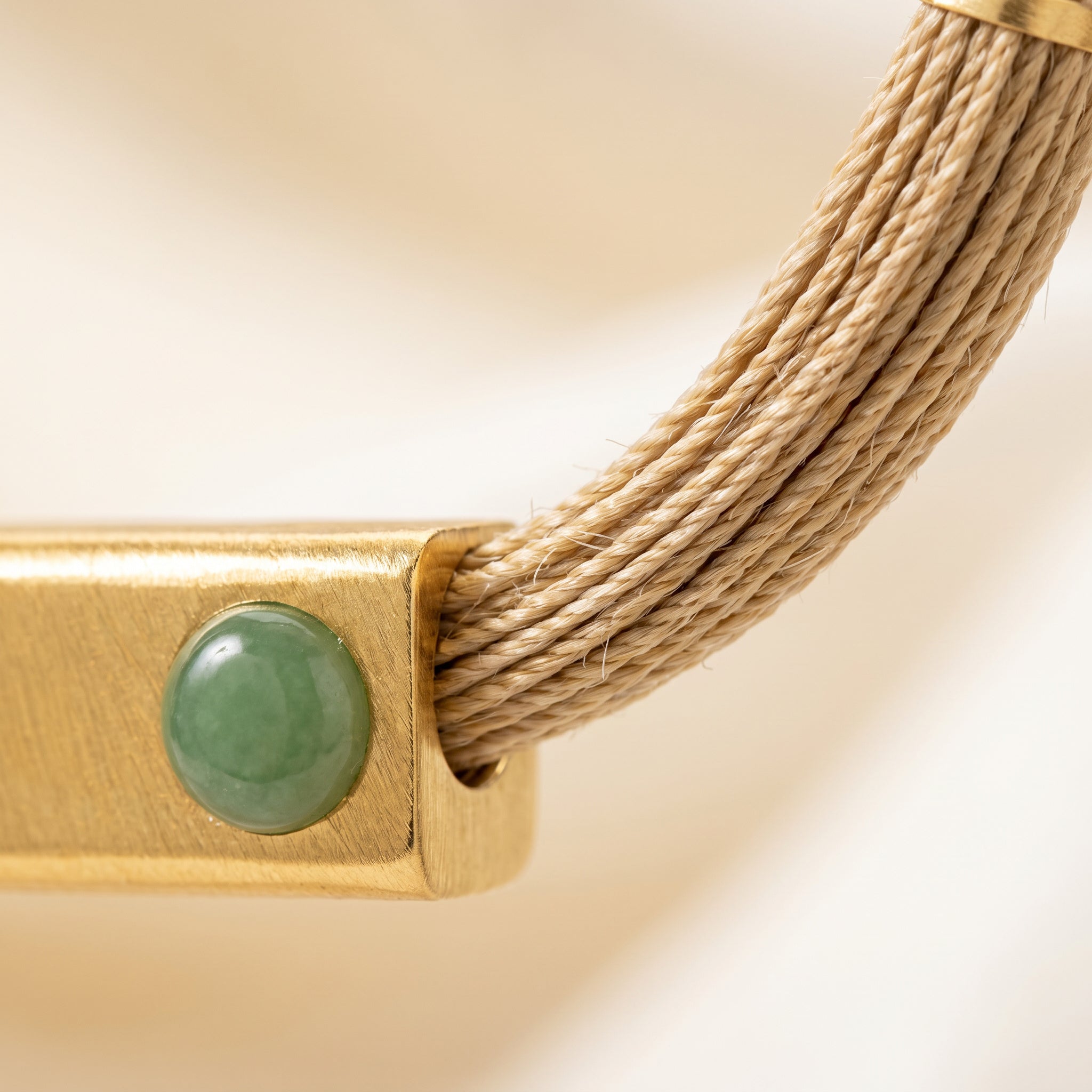 Close-up on a Purplee Store Buriti Geometric Orvellia Necklace and green stone on a beige background