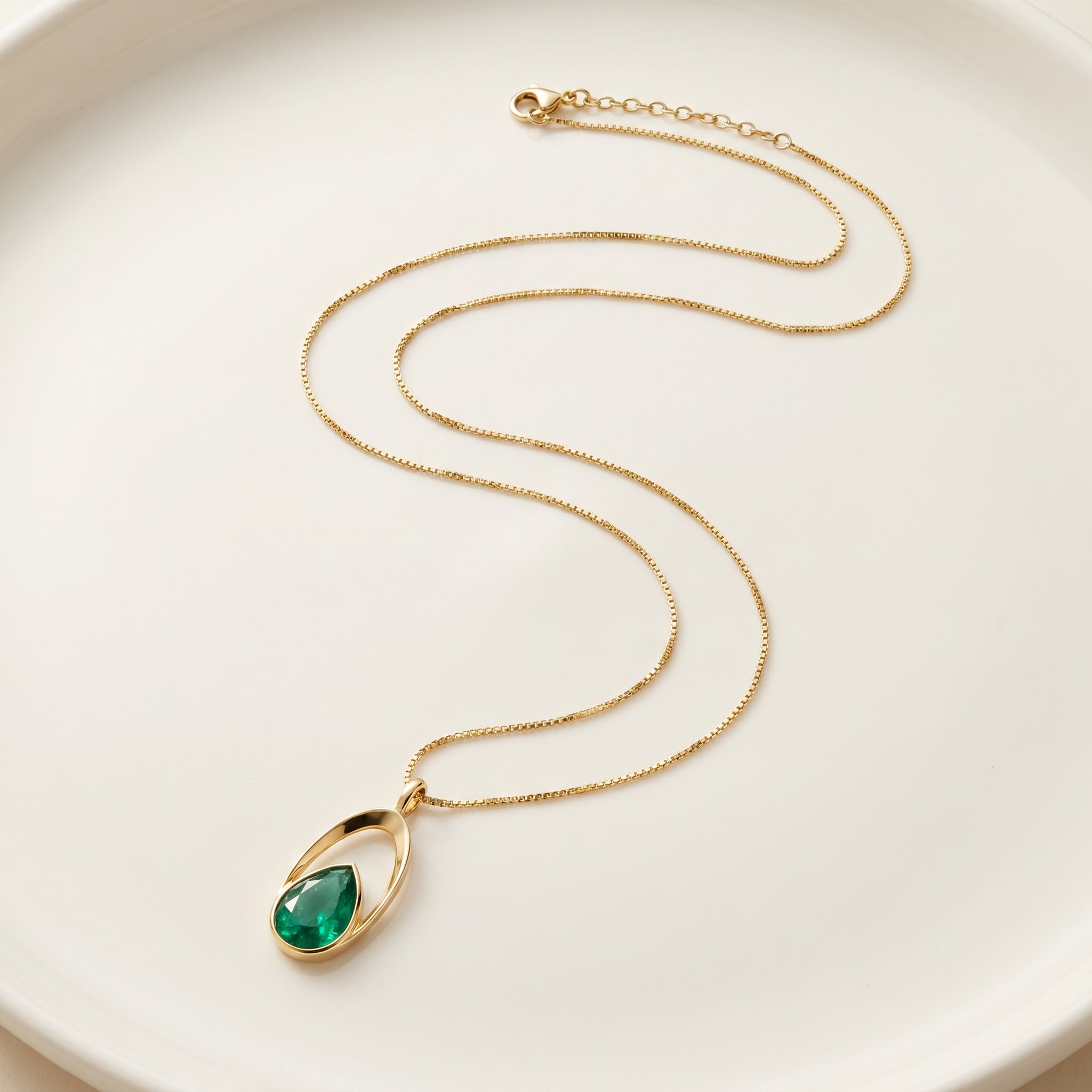 Purplee Store ELAN Emerald Halo Necklace pendant on a white plate