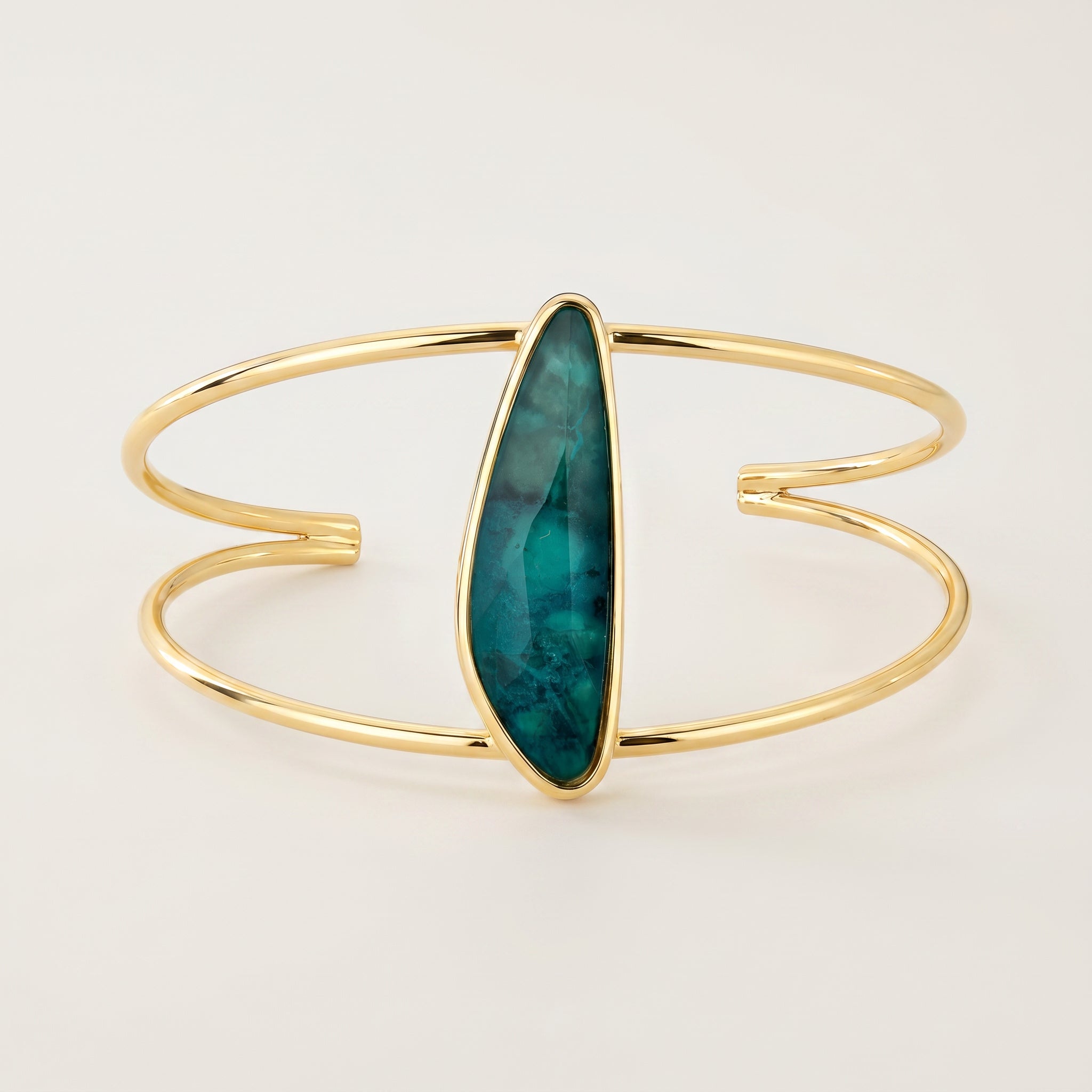 Purplee Store ELAN Emerald Sculptural Cuff on a light beige background