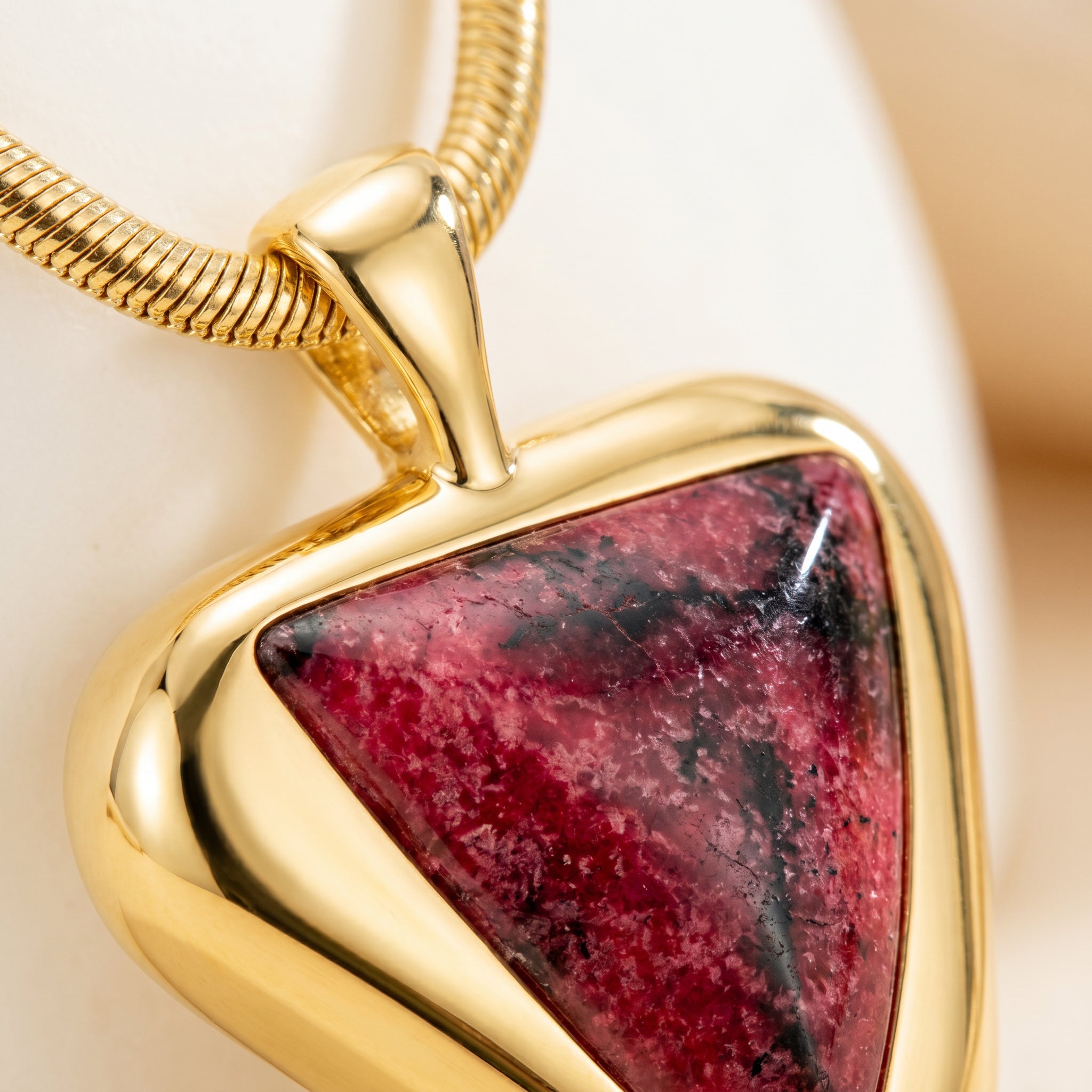 Close-up on a Purplee Store ICON Eclipse Luxury Rhodonite Pendant Necklace on a light background