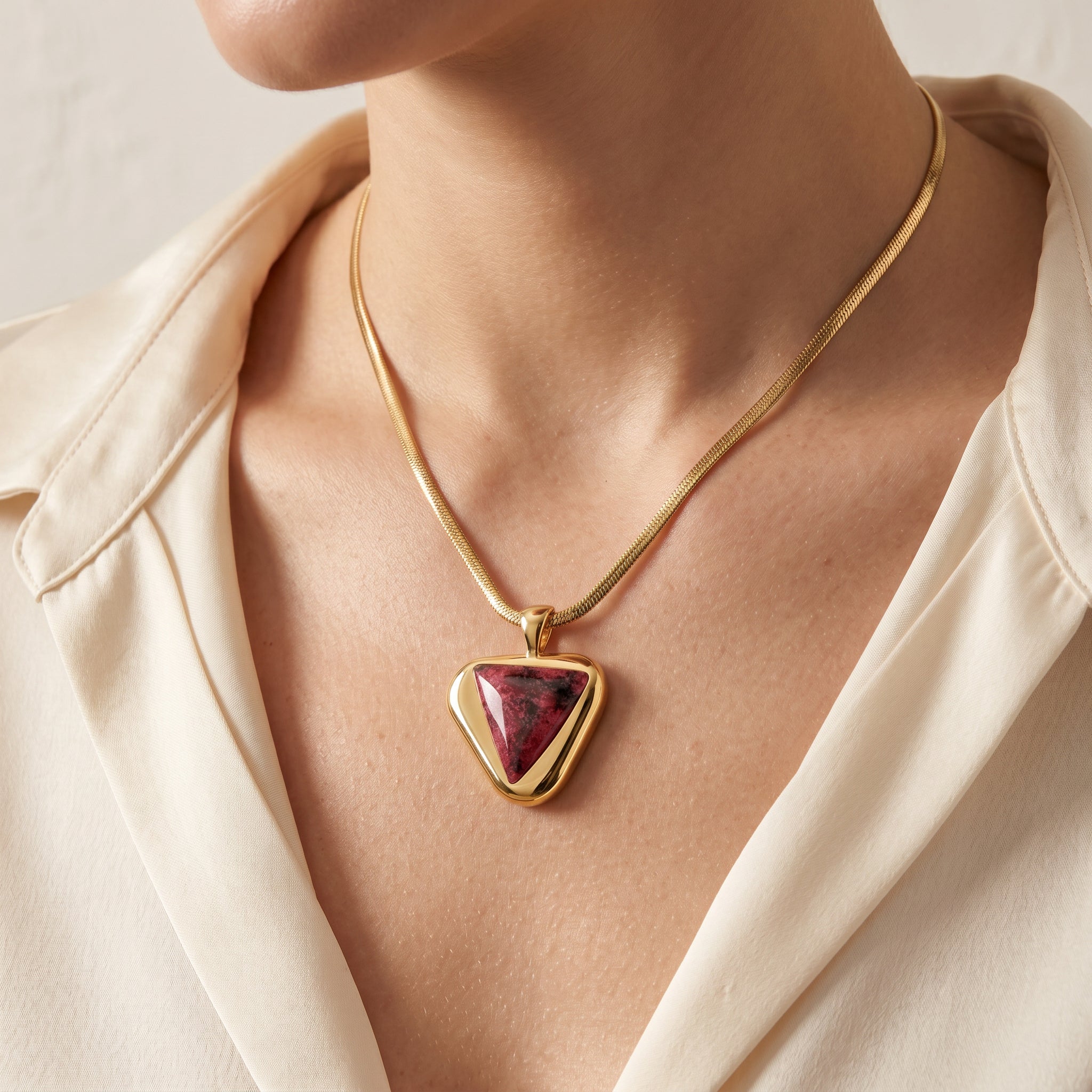 Purplee Store ICON Eclipse Luxury Rhodonite Pendant Necklace worn by a person in a beige shirt.