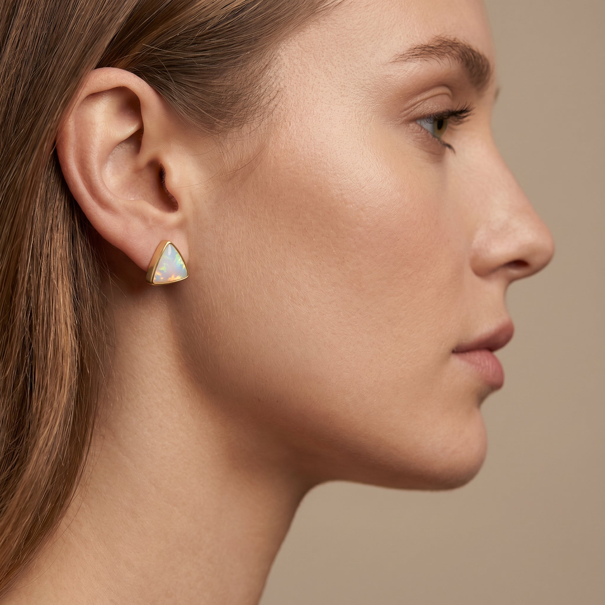 Close-up of a woman wearing a Purplee Store ICON Luxury Triad Opal Earrings against a neutral background