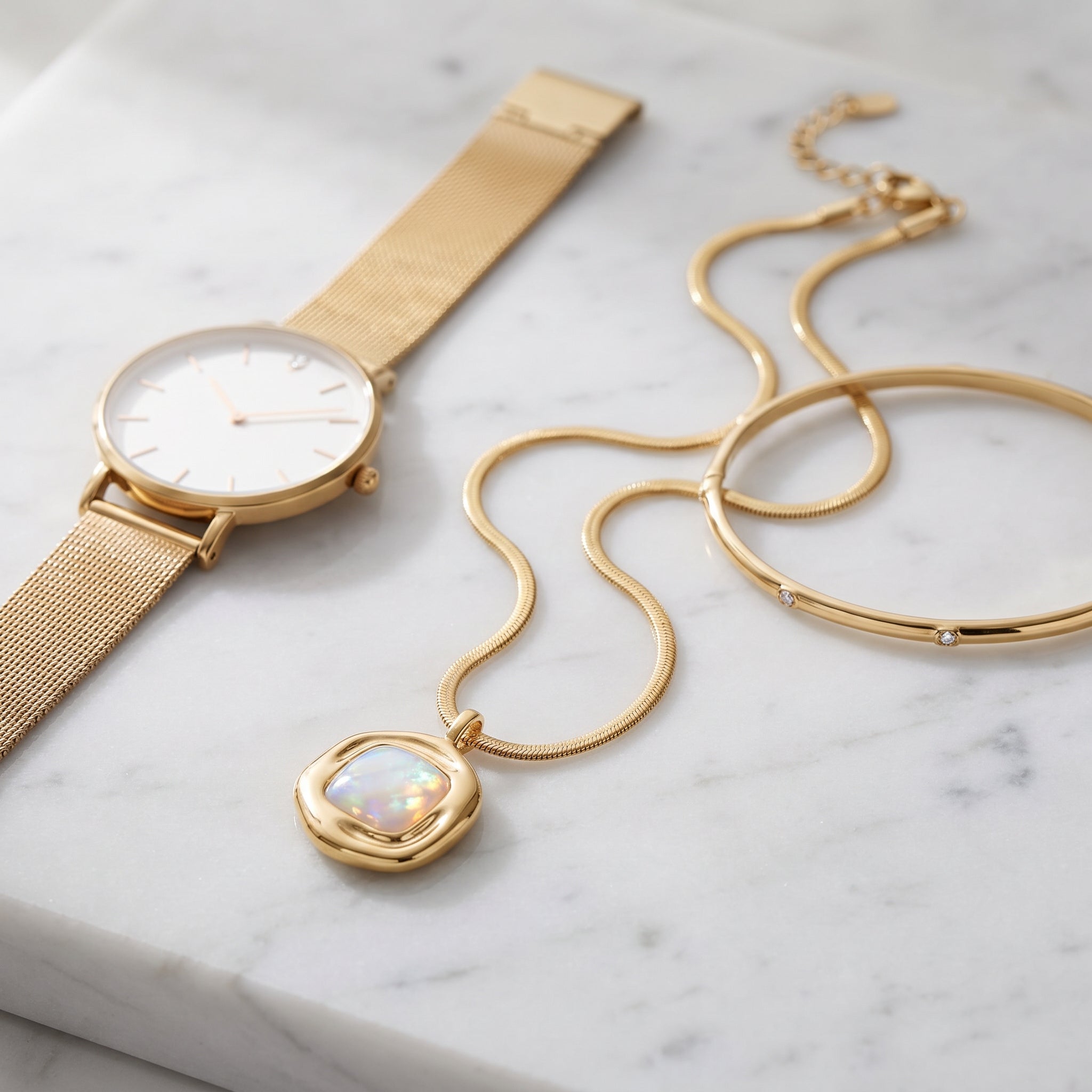 Gold watch and Purplee Store ICON Nautilus Opal Architectural Necklace on a marble surface