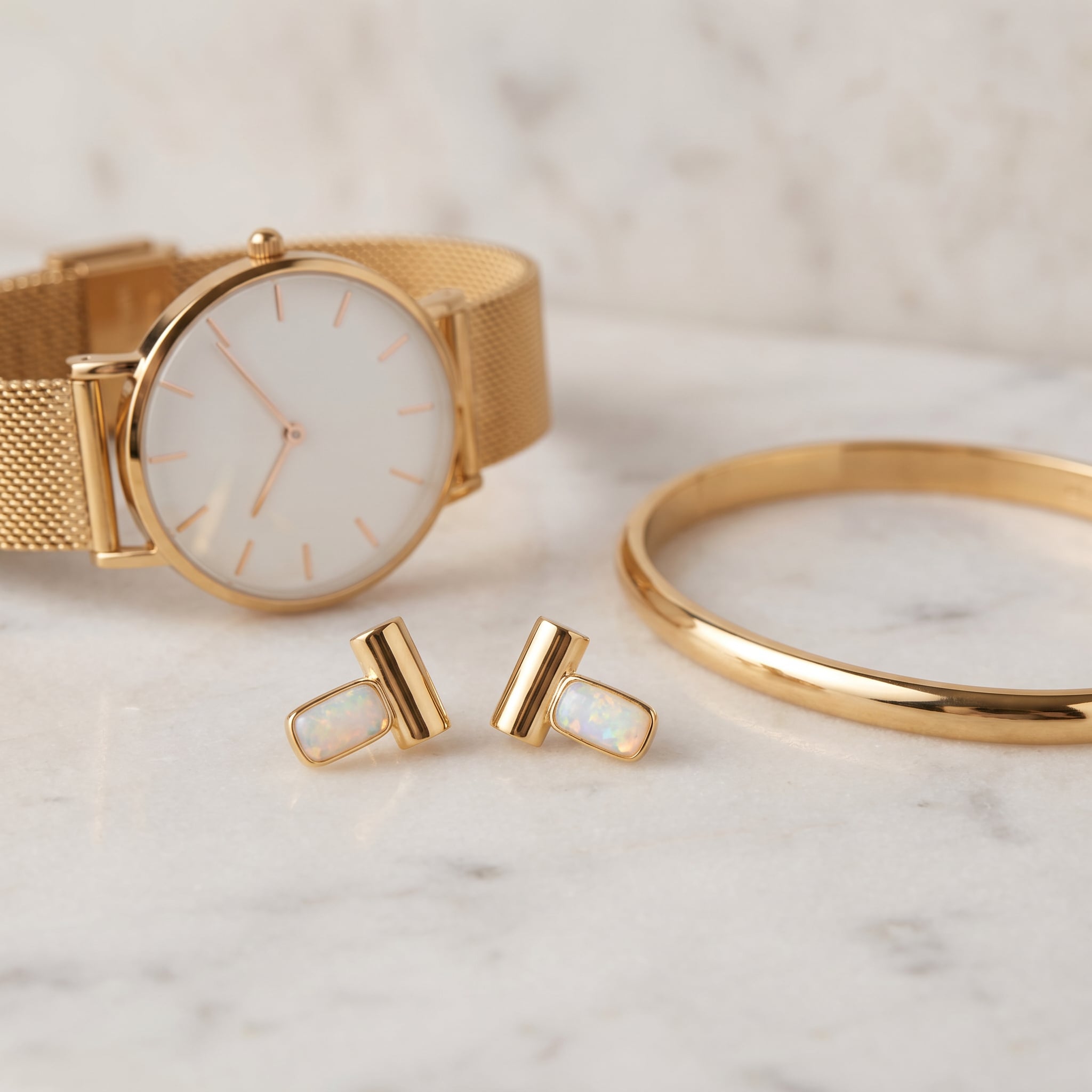 Gold watch, bracelet, and Purplee Store ICON Prism Opal Luxury Earrings on a marble surface