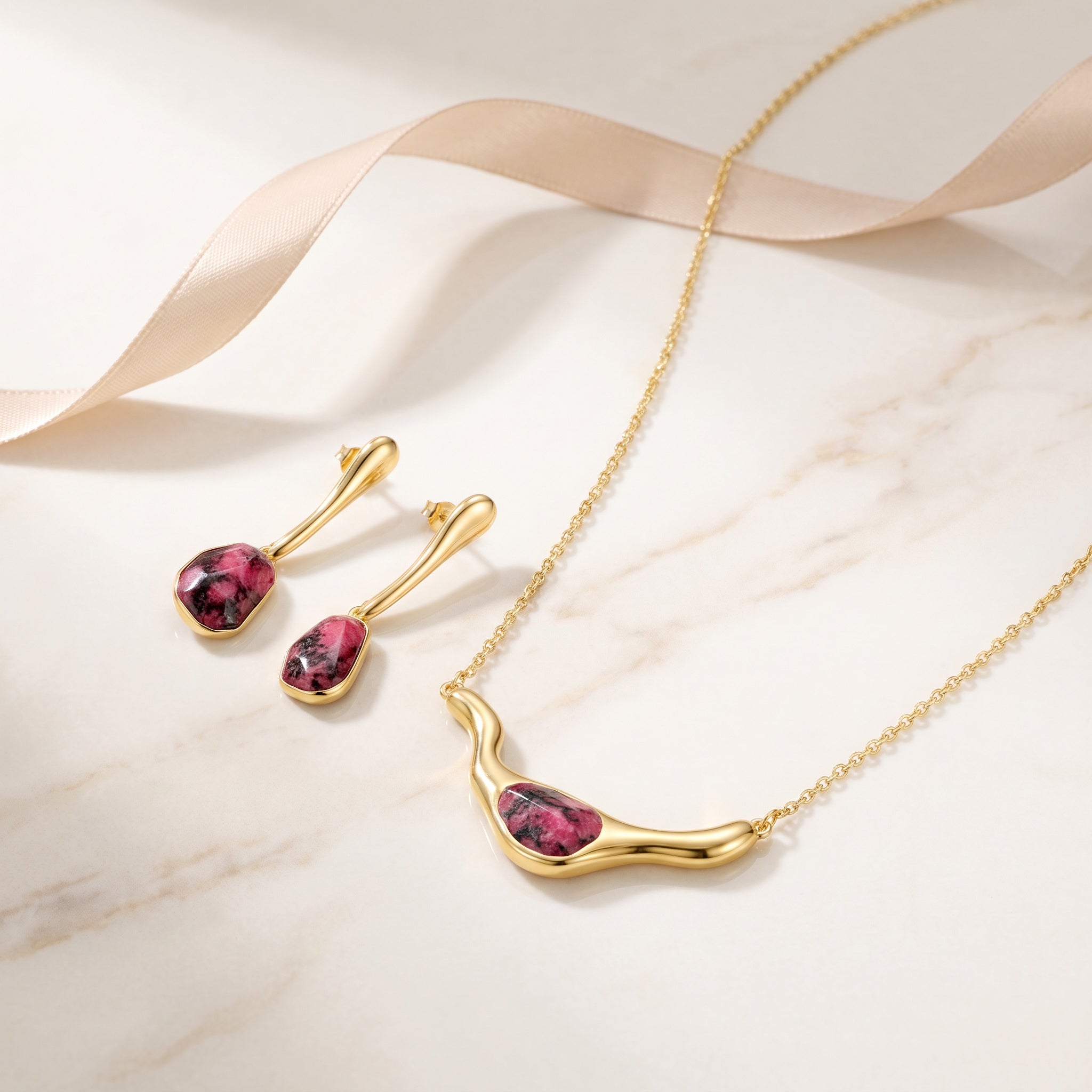 Purplee Store ICON Rhodonite Statement set on a marble surface