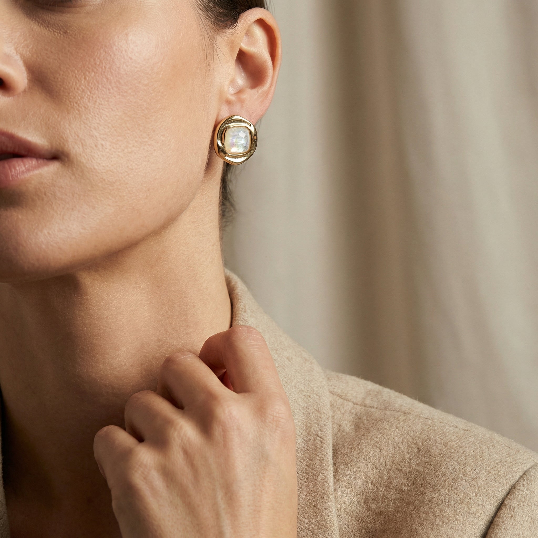 Close-up of a woman wearing Premium 24K Gold Plated Statement Hoop Earrings with Genuine Opal of the Sea with a neutral background. Purplee Store