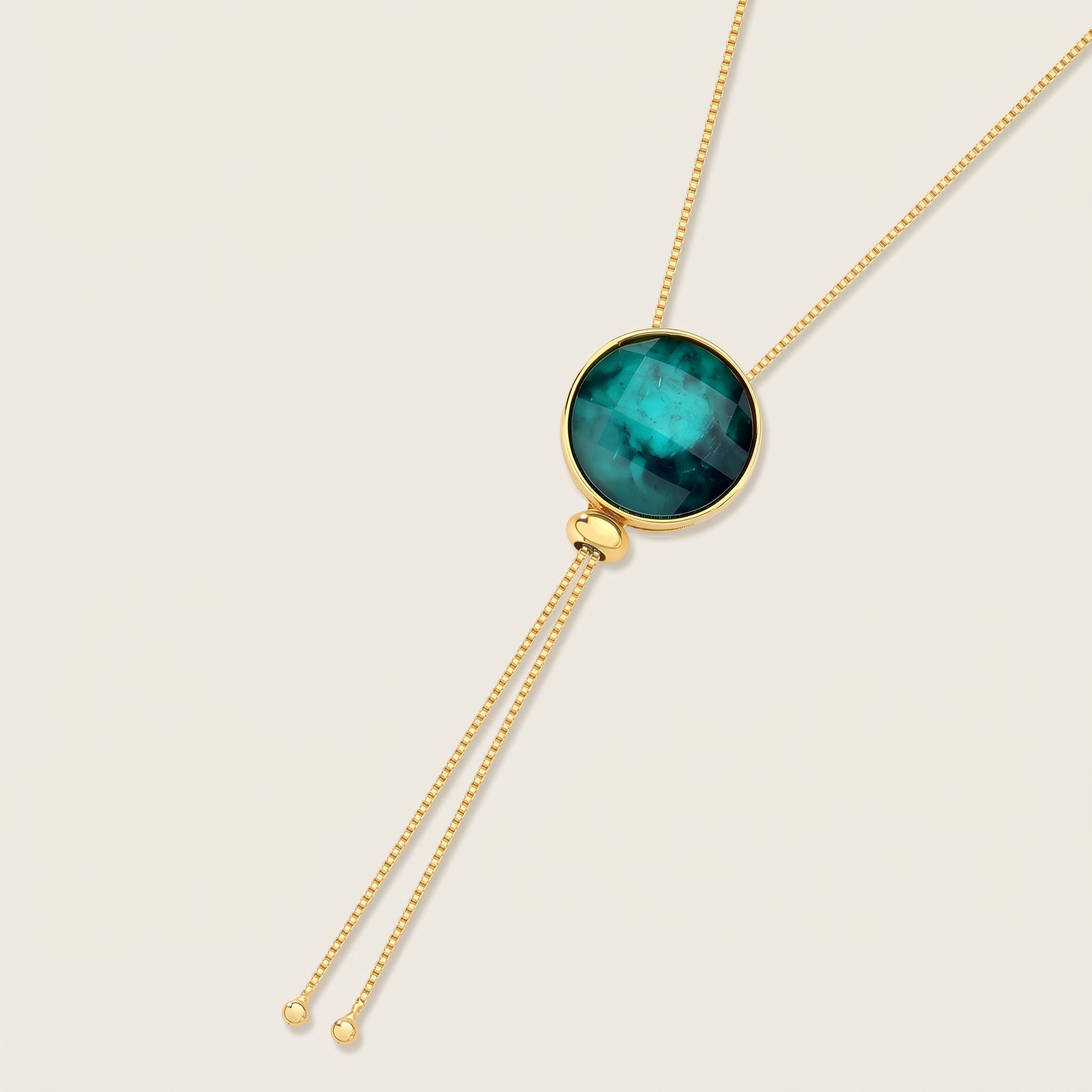 Purplee Store ELAN Emerald Statement necklace pendant on a beige background