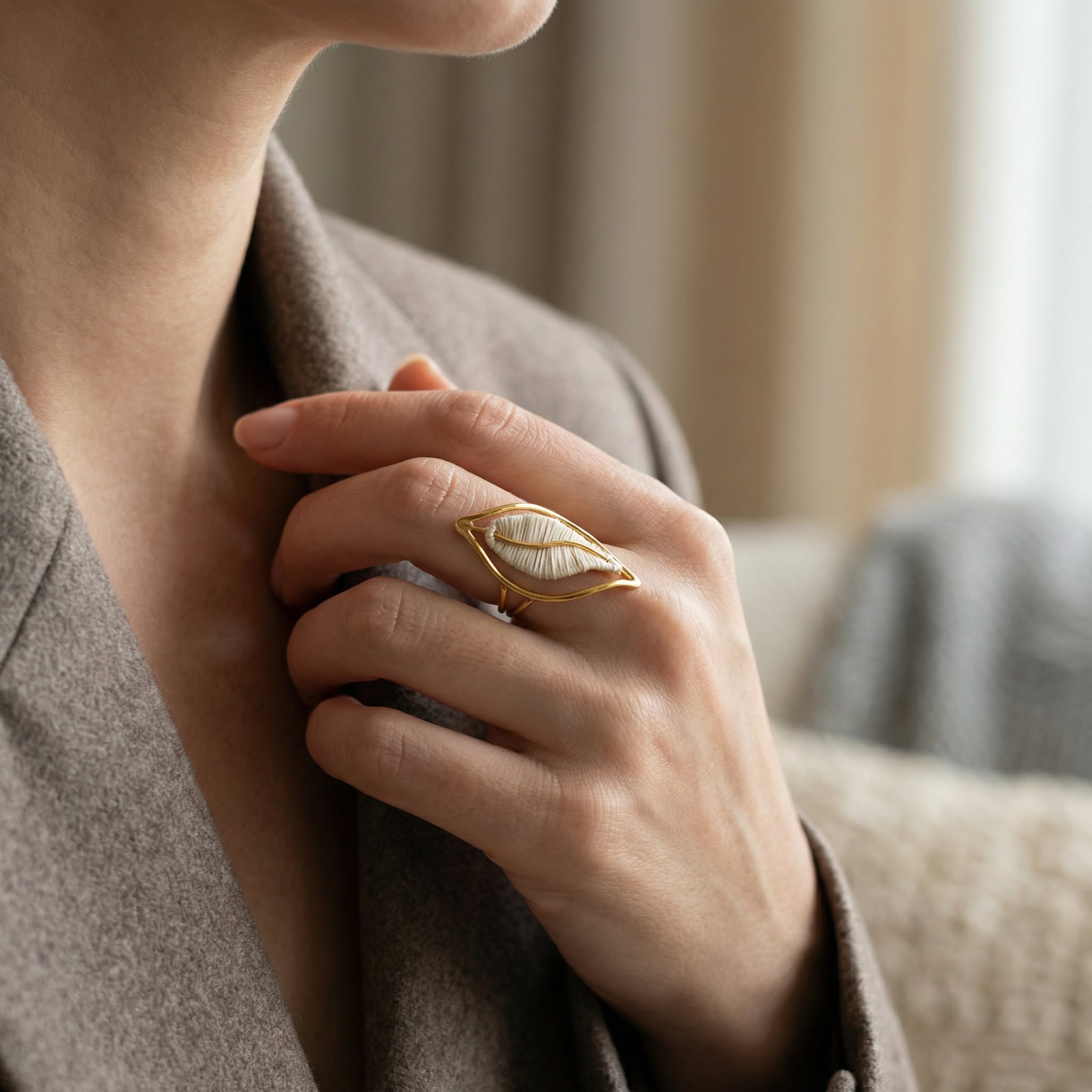 Close-up of a hand wearing a Valiane Ring: Buriti Fiber & 18k Gold Artisan Jewelry with a blurred background.Purplee Store