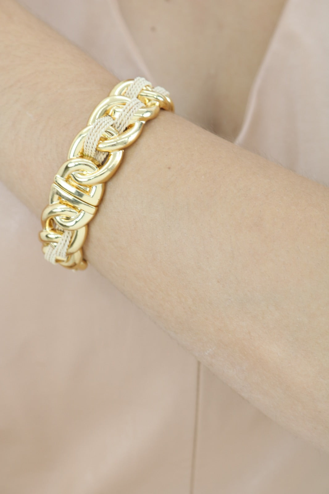 Brazo de mujer usando Brazalete de Purplêe Store hecha a mano con palha de burití y eslabones dorados – joya sostenible de diseño audaz y elegante