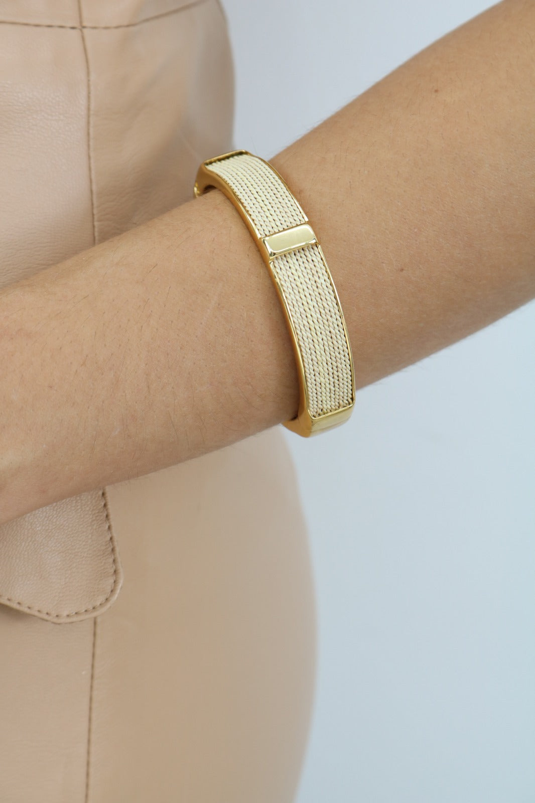 Mujer executive usando Pulsera rígida de Purplêe Store hecha a mano en palha de burití con cierre dorado – joya sostenible, moderna y elegante