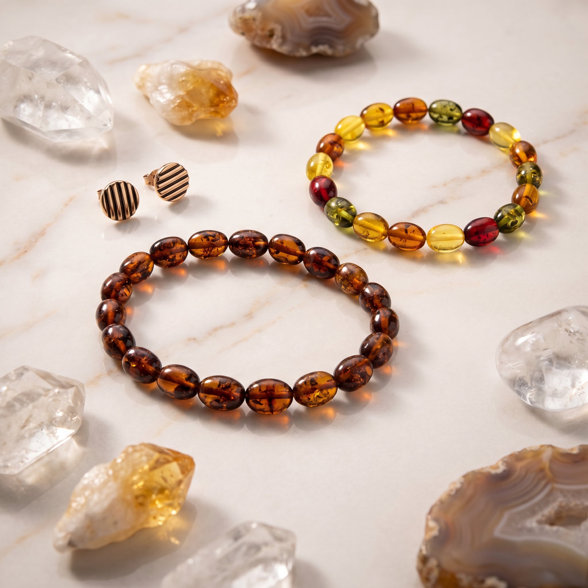 Two amber bracelets on a marble surface with crystals and stones|Purplee Store.